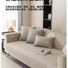A beige linen sofa cover cushion is displayed on a light-colored sofa with matching pillows.