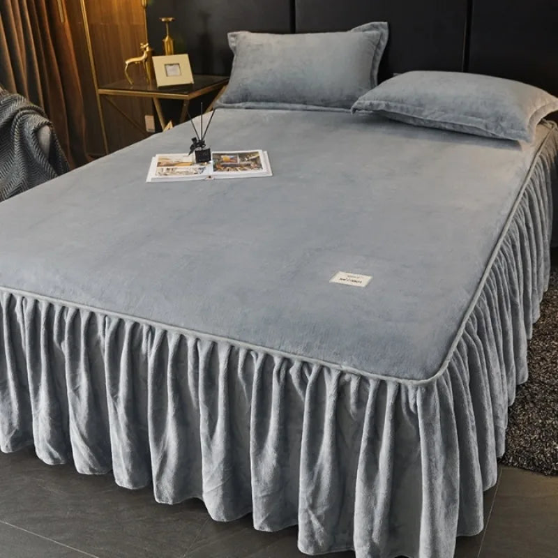 A thick gray milk velvet bed skirt draped over a bed, used for cozy autumn and winter decor.