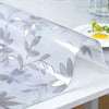Clear PVC tablecloth with silver leaf pattern draped over a white table.