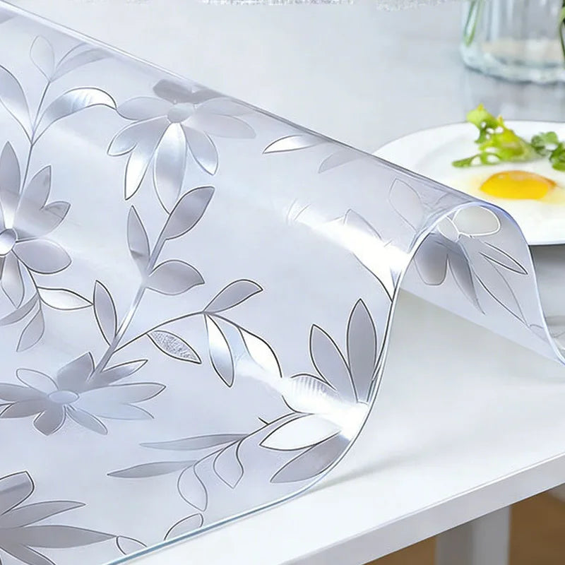 Clear PVC tablecloth with silver leaf pattern draped over a white table.