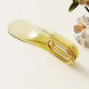 A translucent yellow mattress lifter wedge is shown against a light background with a flower in the upper right corner.