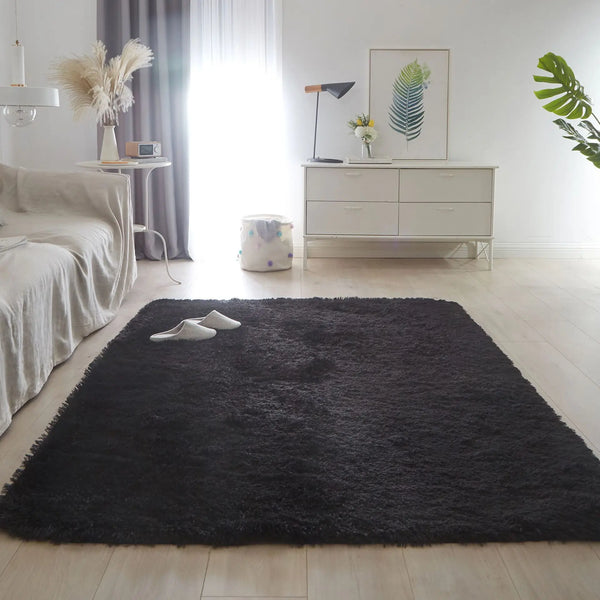 A luxurious black furry area rug placed on a light wood floor in a bright, minimalist room.