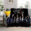 A black fleece throw blanket featuring a photo of the Stray Kids Kpop group members.