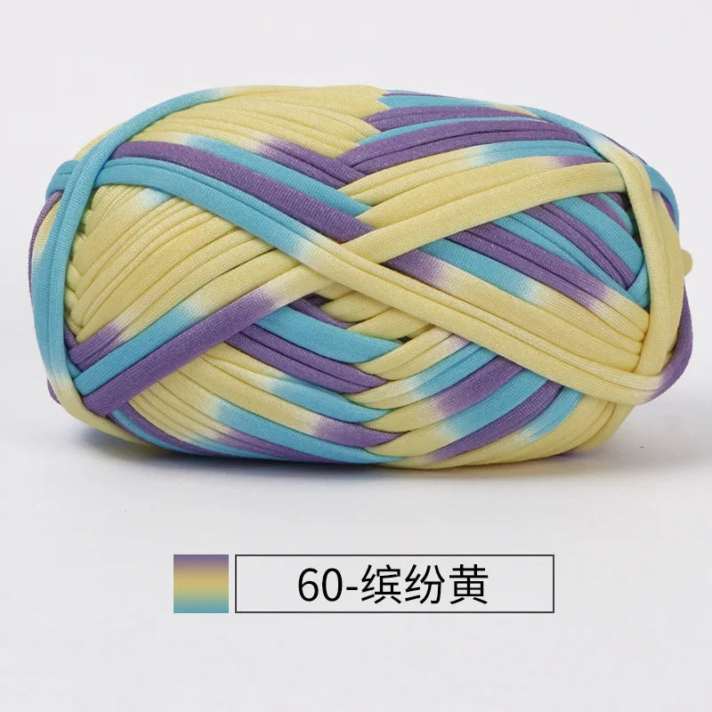 A ball of hand-dyed fabric strip yarn featuring yellow, purple, and blue stripes.