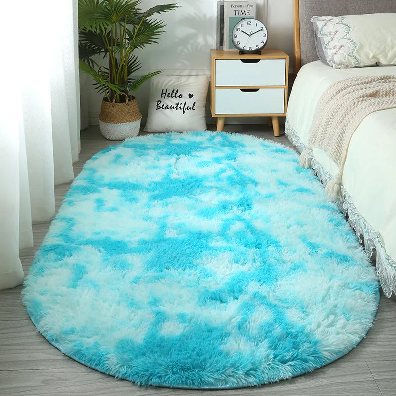 A bright turquoise plush floor mat placed on a light wood floor next to a white bed and potted plant.
