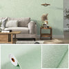 Light sage green self-adhesive 3D thermal insulation wallpaper with a linen texture on a wall.