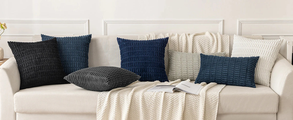 A sofa decorated with various indigo and beige textured throw pillows.