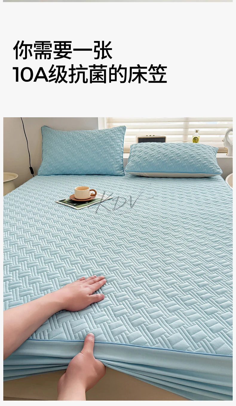 A hand is touching a light blue cooling spandex fitted sheet mattress protector on a bed.