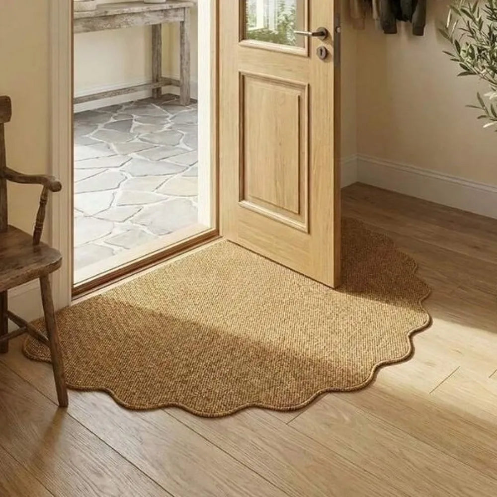 A natural jute non-slip entrance door mat placed on a light wood floor next to a wooden chair and a glass-paned door.