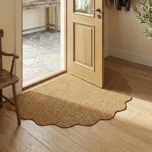 A natural jute non-slip entrance door mat placed on a light wood floor next to a wooden chair and a glass-paned door.
