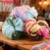 A pile of hand-woven chunky chenille yarn in various pastel and earthy colors, including pink, purple, green, and brown.