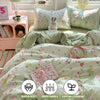 A light green and pink floral duvet cover set with pillows and a decorative fabric tag showing features like super soft breat