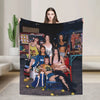 A woman holds up a large print featuring a K-Pop style group with vibrant makeup and clothing.