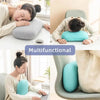 A woman is shown using a light blue memory foam neck and travel pillow for support while working on a laptop.