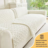 A cream quilted sofa cushion with a removable cover shown on a light gray sofa.