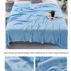 A light blue bamboo fiber blanket draped over a bed, highlighting its soft texture and breathable qualities.