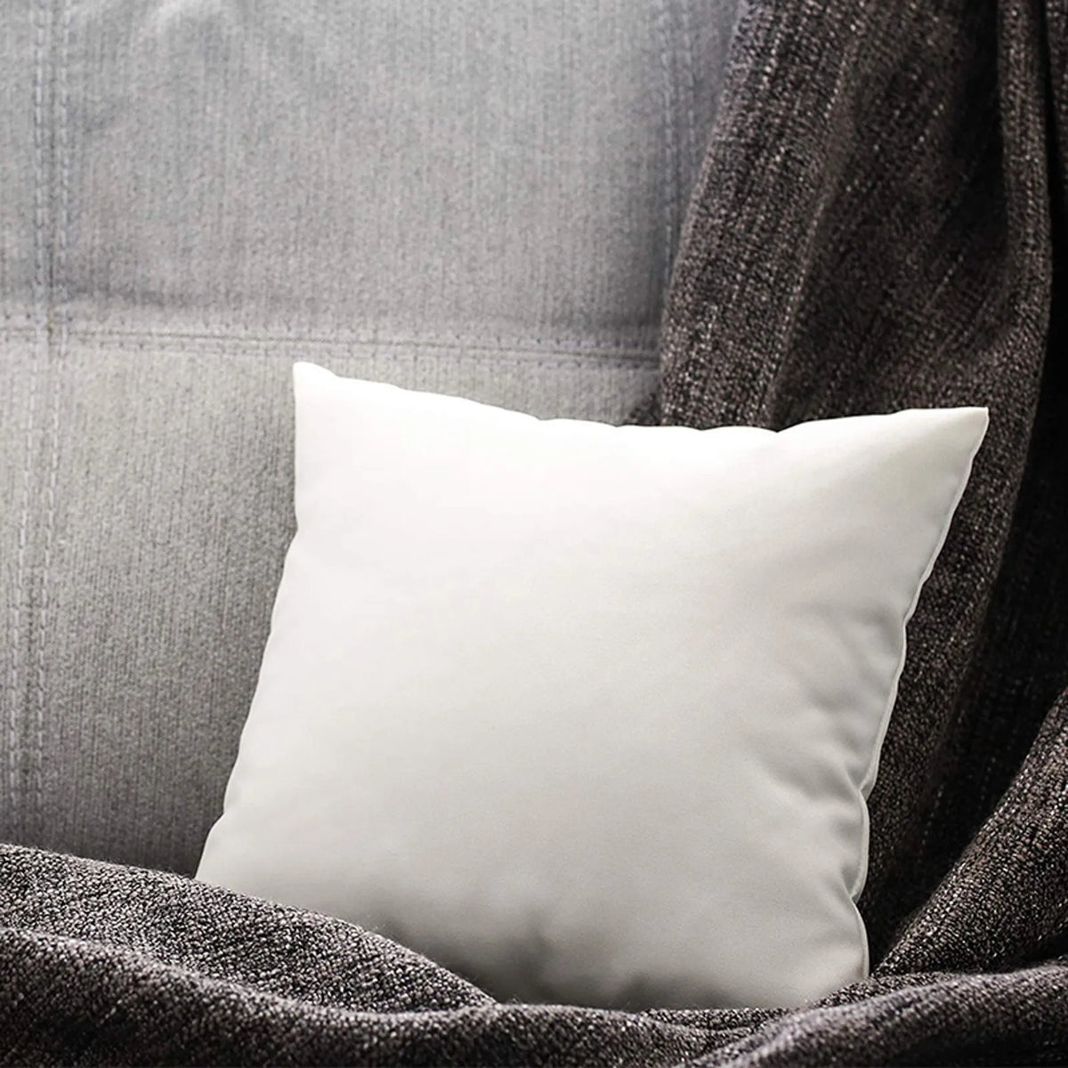 A white soft cotton-padded headboard cushion resting on a dark gray fabric.