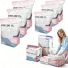 Multiple pink and white space-saving vacuum storage bags are displayed, some filled with fabric.