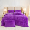 A purple plush duvet cover set with matching pillows displayed on a bed against a light background.