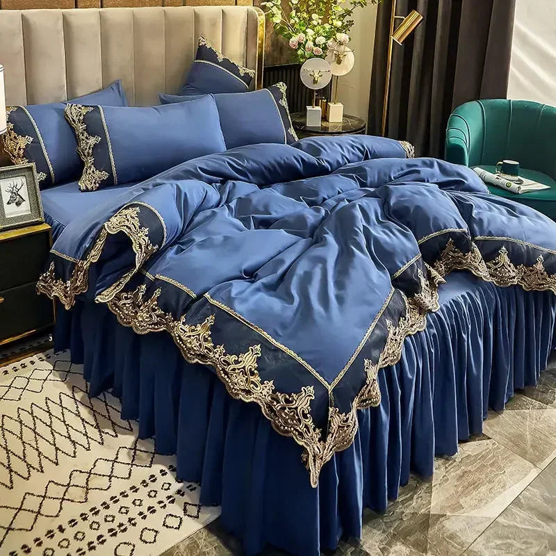 A royal blue bed skirt set with intricate gold lace edging and gathered fabric, displayed in a bedroom setting.
