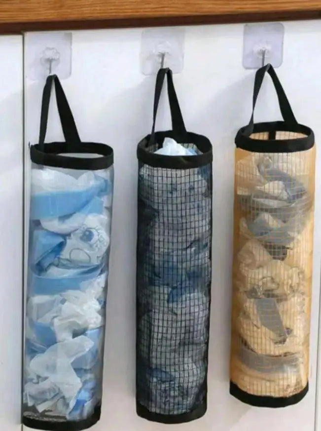 Wall mounted dispenser rack holding three clear plastic bags with blue and white designs