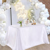 A white satin tablecloth is set up for an elegant party decor display featuring balloons and a cake.