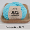 A ball of light blue organic cotton yarn is displayed on a wooden tray.