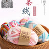 A collection of hand-dyed fabric strip yarn in various pastel colors is displayed in a woven basket.