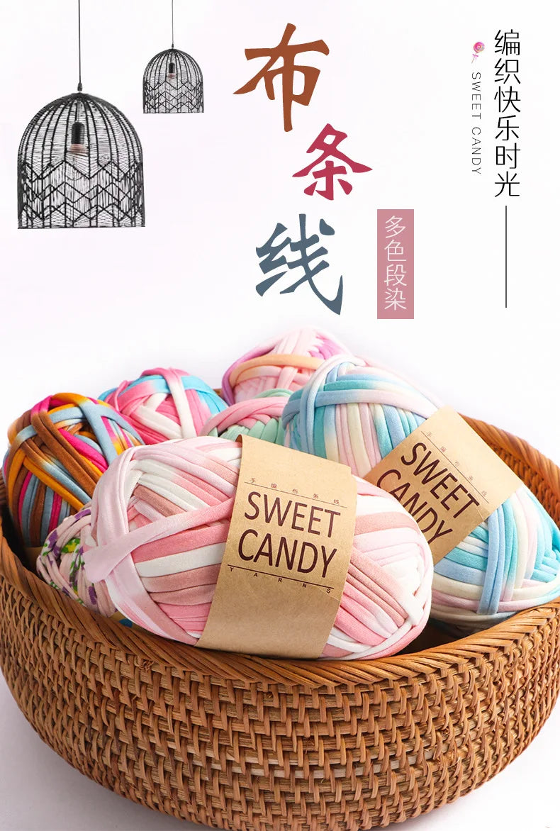 A collection of hand-dyed fabric strip yarn in various pastel colors is displayed in a woven basket.