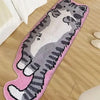 A pink decorative cat mat featuring a gray and white striped cat design placed on a wooden floor.