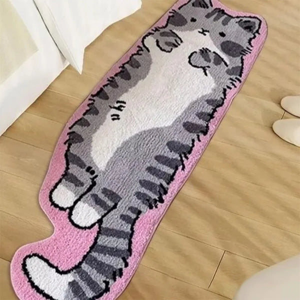 A pink decorative cat mat featuring a gray and white striped cat design placed on a wooden floor.