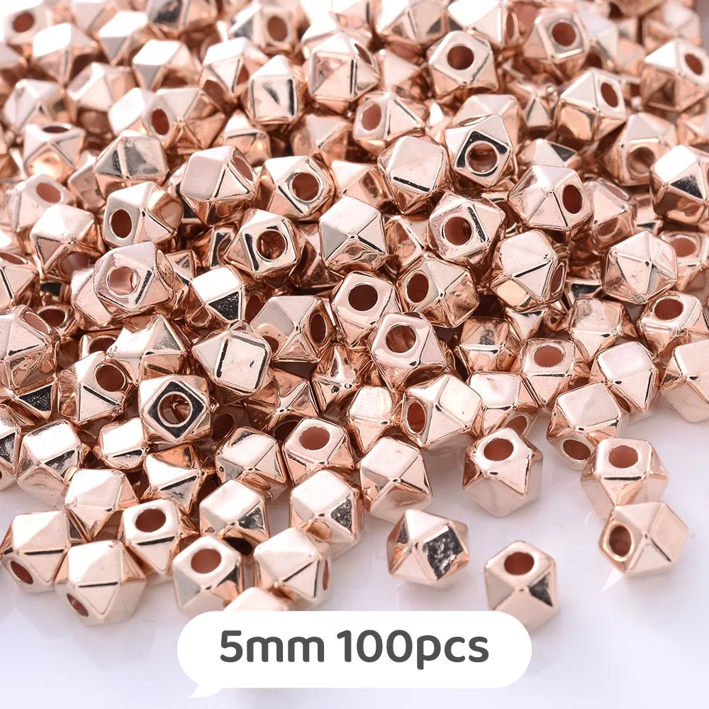 A pile of rose gold geometric acrylic beads, approximately 5mm in size, for jewelry making.