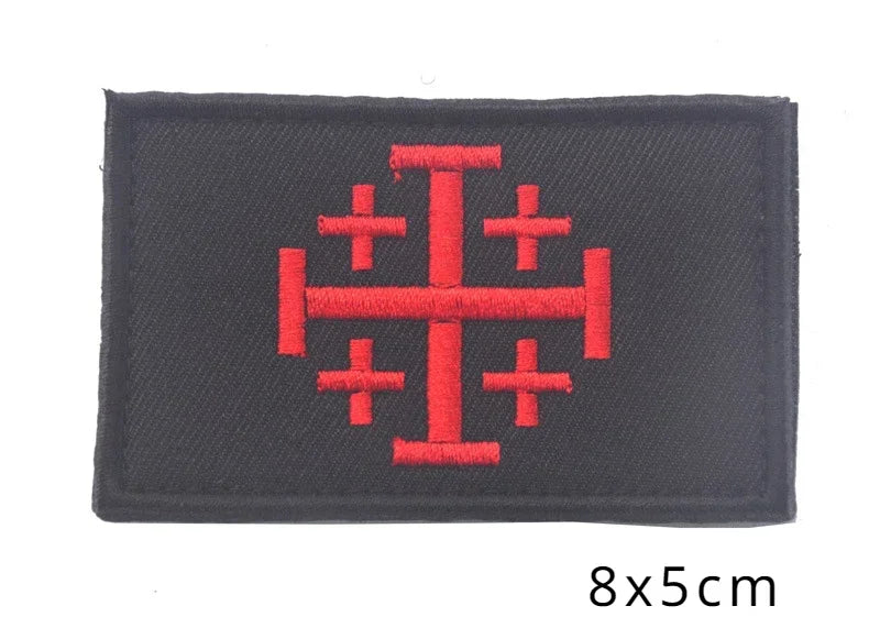 Black embroidered patch featuring a red cross design.
