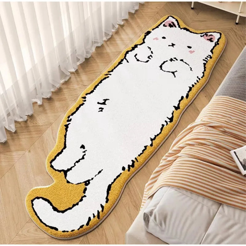 A long, yellow decorative cat mat with a white body and pink accents is placed on a wooden floor next to a bed.