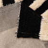 Close-up of a vintage bohemian knit sofa protector featuring black and cream geometric patterns.