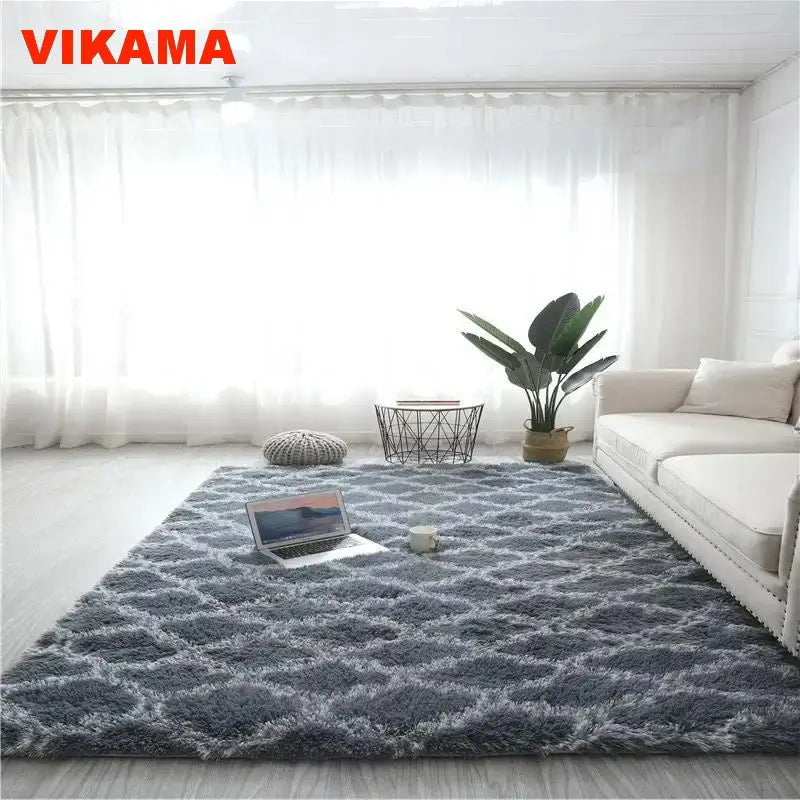 A gray geometric plush area rug placed on a light wooden floor in a bright living room.