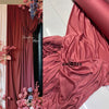 A close-up of flowing dusty rose fabric draped elegantly, used for decor.