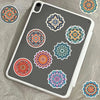 A gray phone case featuring several colorful mandala graffiti stickers.