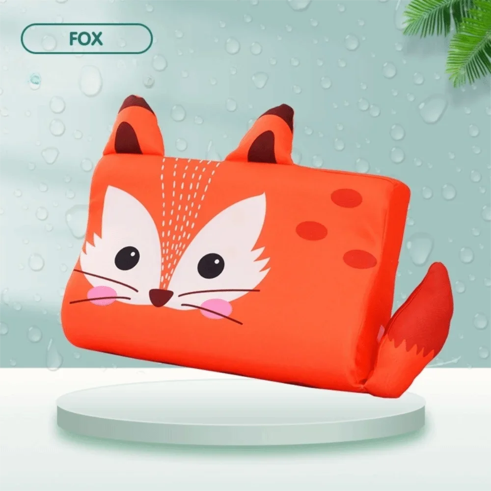 An orange fox-shaped memory foam neck pillow for toddlers resting on a white surface.
