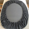 A circular gray velvet fabric drape or cover for bedding.