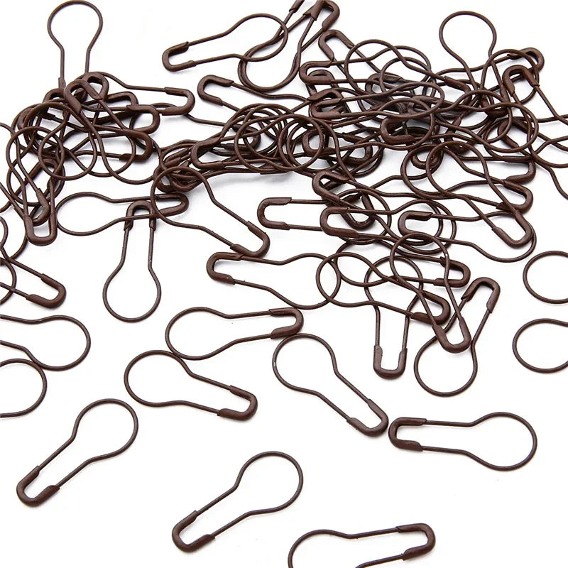 A pile of dark brown safety bulb pins for knitting and sewing
