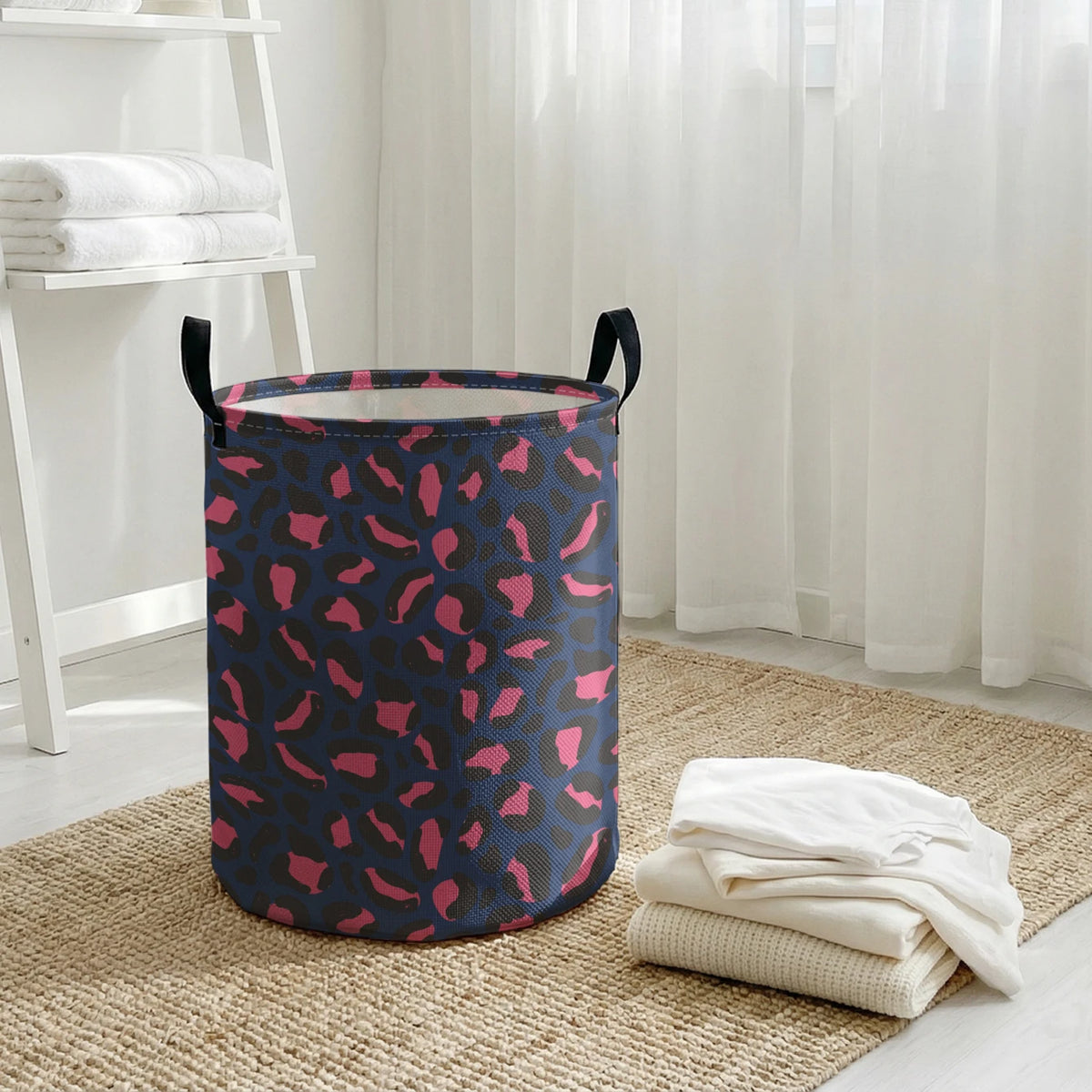 A navy blue laundry basket with a leopard print pattern sits on a beige rug next to sheer white curtains.