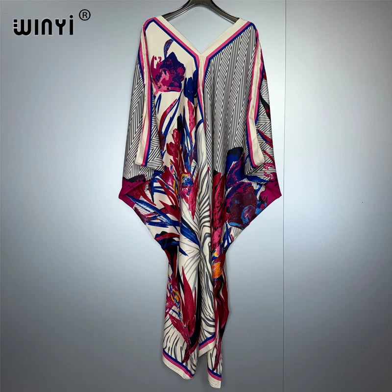 A long maxi dress featuring a bohemian floral print with pink, purple, and white patterns.