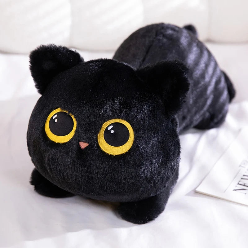 A black plush cat with large yellow eyes lying on a white surface.