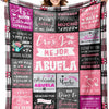 A colorful knitted blanket featuring text in Spanish celebrating a mother and grandmother