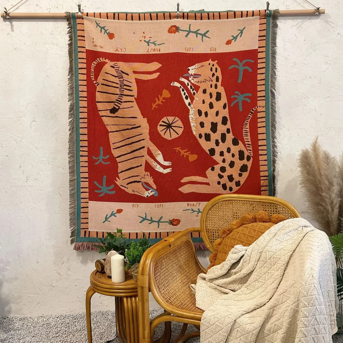 A woven geometric throw blanket featuring a red background with stylized animal motifs and natural elements.