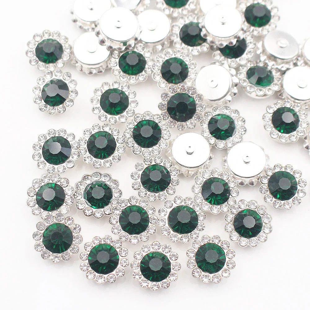 Silver and green crystal rhinestone sew-on buttons arranged in a scattered pattern.