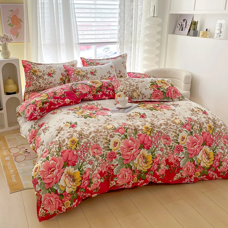 A floral printed duvet cover set featuring pink, red, and yellow flowers with matching pillowcases on a bed.