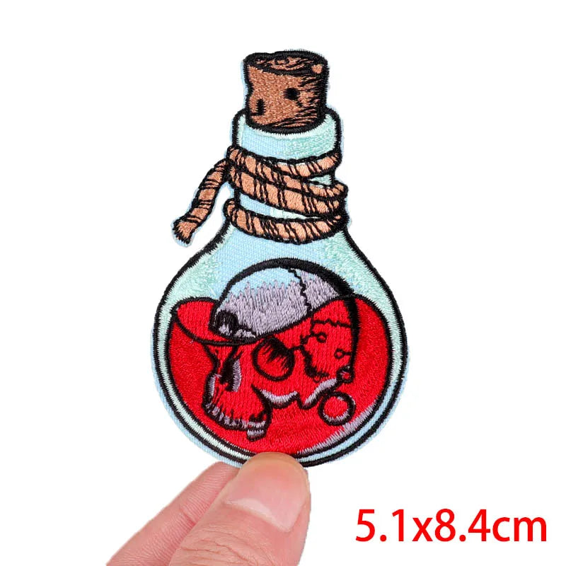 Embroidery patch depicting a rose skull inside a glass bottle with a cork stopper