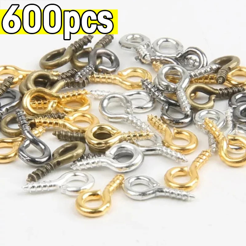 A pile of various silver and gold stainless steel eye screw pins for jewelry making.